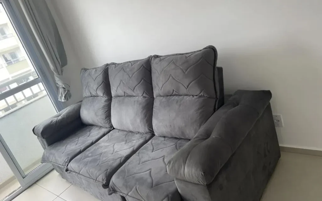Sofá retrátil Paris 2,30m Velut cinza instalado em sala de apartamento
