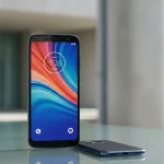 Fx Motorola Moto G75 positioned on a modern glass surface with architectural elements in the blurred background emphasizing contemporary design aesthetics 1