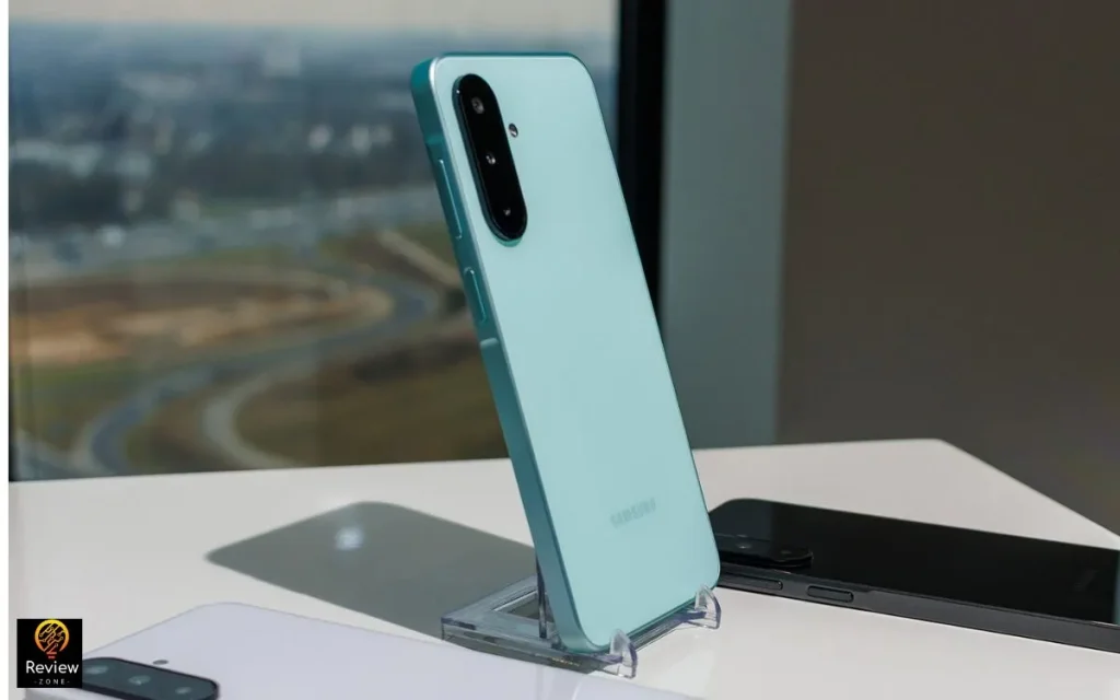 Smartphone Samsung Galaxy A26 na cor azul em suporte acrílico, exibindo módulo de câmera tripla.