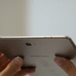 Fx Samsung Galaxy Tab S10 FE held in hands showing thin profile and premium build quality against blurred background 4