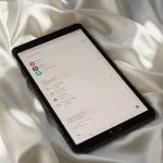 Fx Samsung Galaxy Tab S6 positioned on white silk fabric with elegant draping and soft light 1