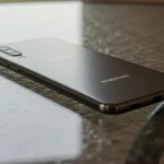 Fx Samsung affordable phone placed on a glass surface creating subtle reflections 4