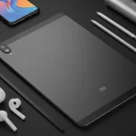 Fx Top down view of a Xiaomi Mi Pad surrounded by modern tech accessories like wireless earbuds stylus and smartphone on a dark surface 3