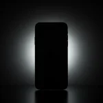 Fx iPhone 16e with dramatic backlighting creating halo effect silhouette style with subtle details visible artistic product photography approach 2
