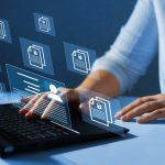 Pessoa usando laptop com ícones de documentos digitais na tela.